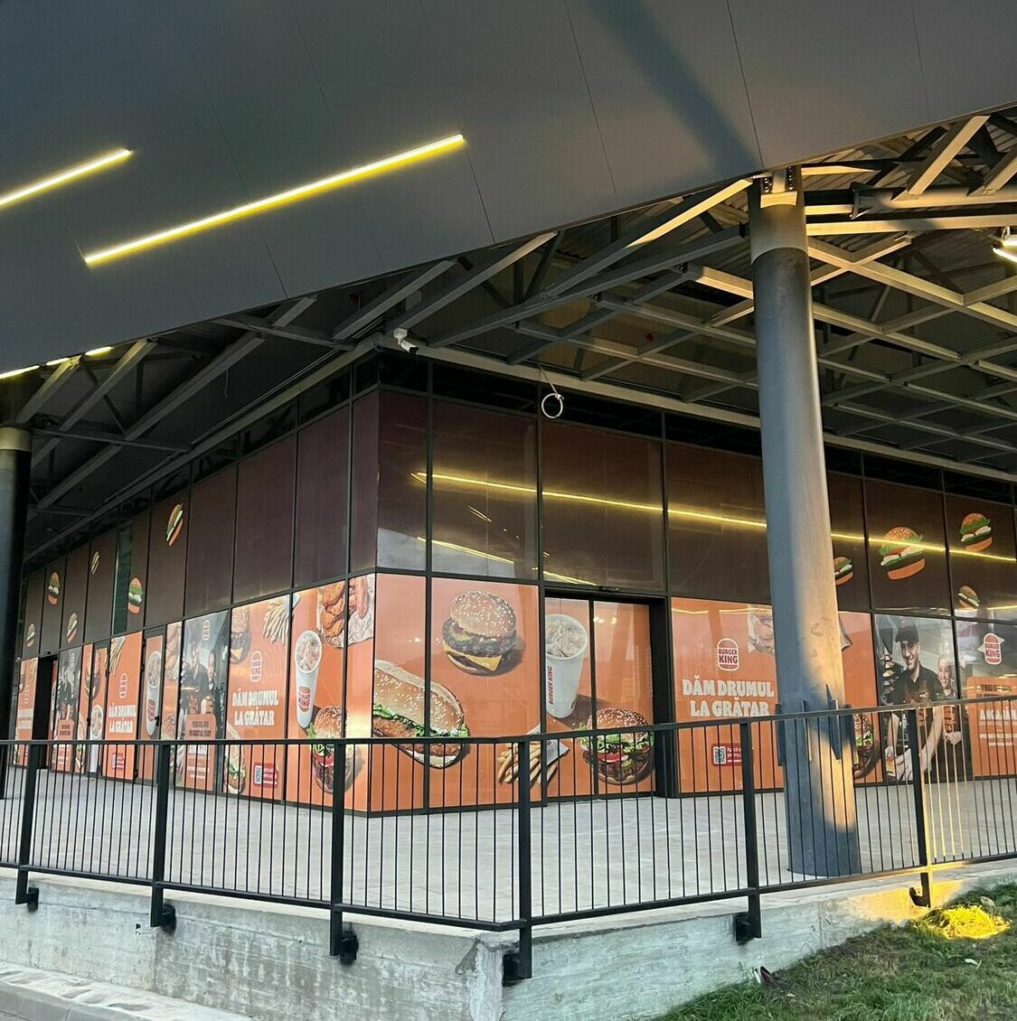 Imbracare fațadă mall autocolant și mesh Burger King Imbracarea fațadei unui mall cu autocolant și mesh pentru renumitul Burger King, inclusiv printare, grafică și montaj profesional