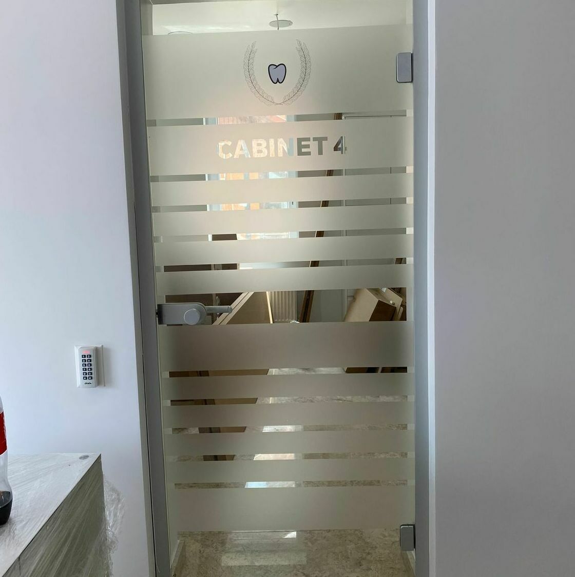 Decorare geam cabinet stomatologic Sibiu - Folie sablată aplicată Decorarea geamului pentru cel mai mare cabinet stomatologic din Sibiu cu folie sablată aplicată, design interior profesional și elegant.